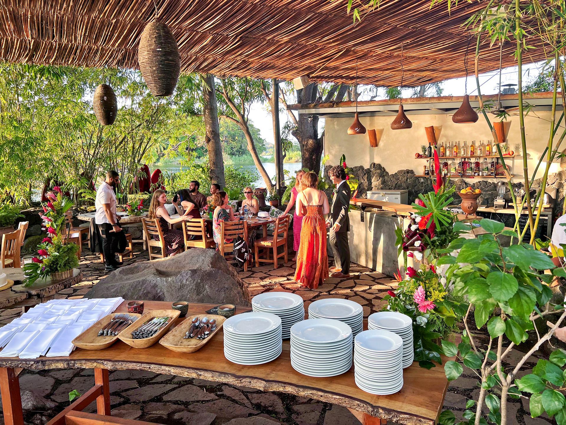 Outdoor restaurant setting with people dining, a bar, and food service area.