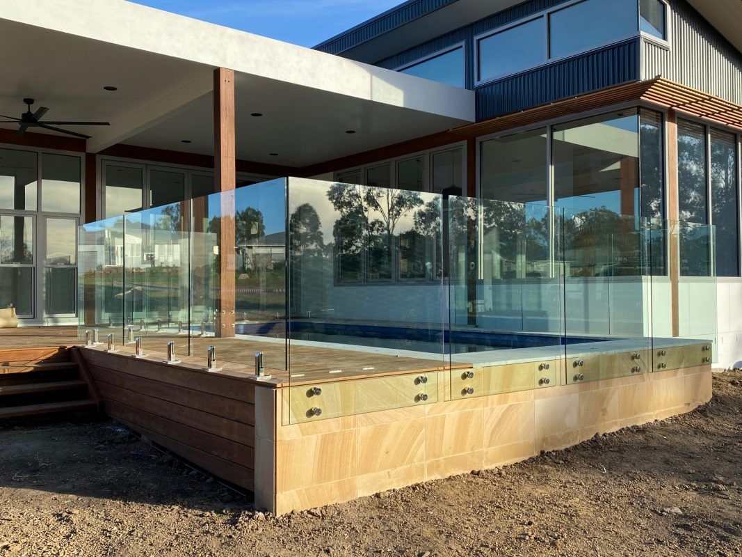 A House With a Swimming Pool and a Glass Fence Around It — Reflect Glass In Lake Macquarie, NSW