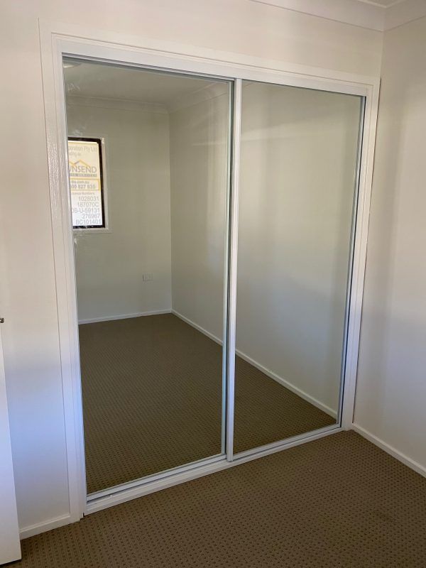 A Bedroom With Sliding Glass Doors and a Window — Reflect Glass In Newcastle, NSW
