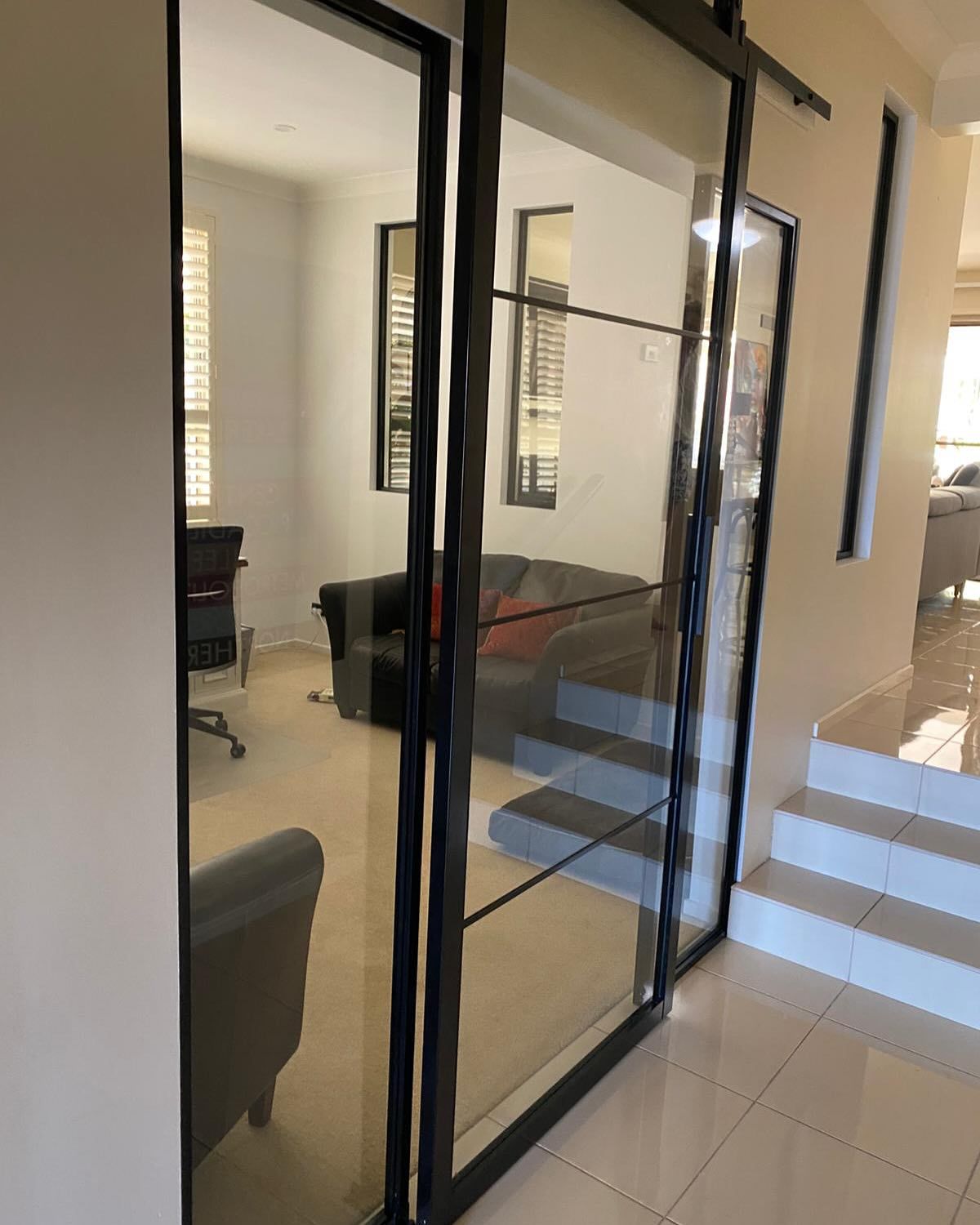A Living Room with A Sliding Glass Door and Stairs — Reflect Glass In Tuggerah, NSW