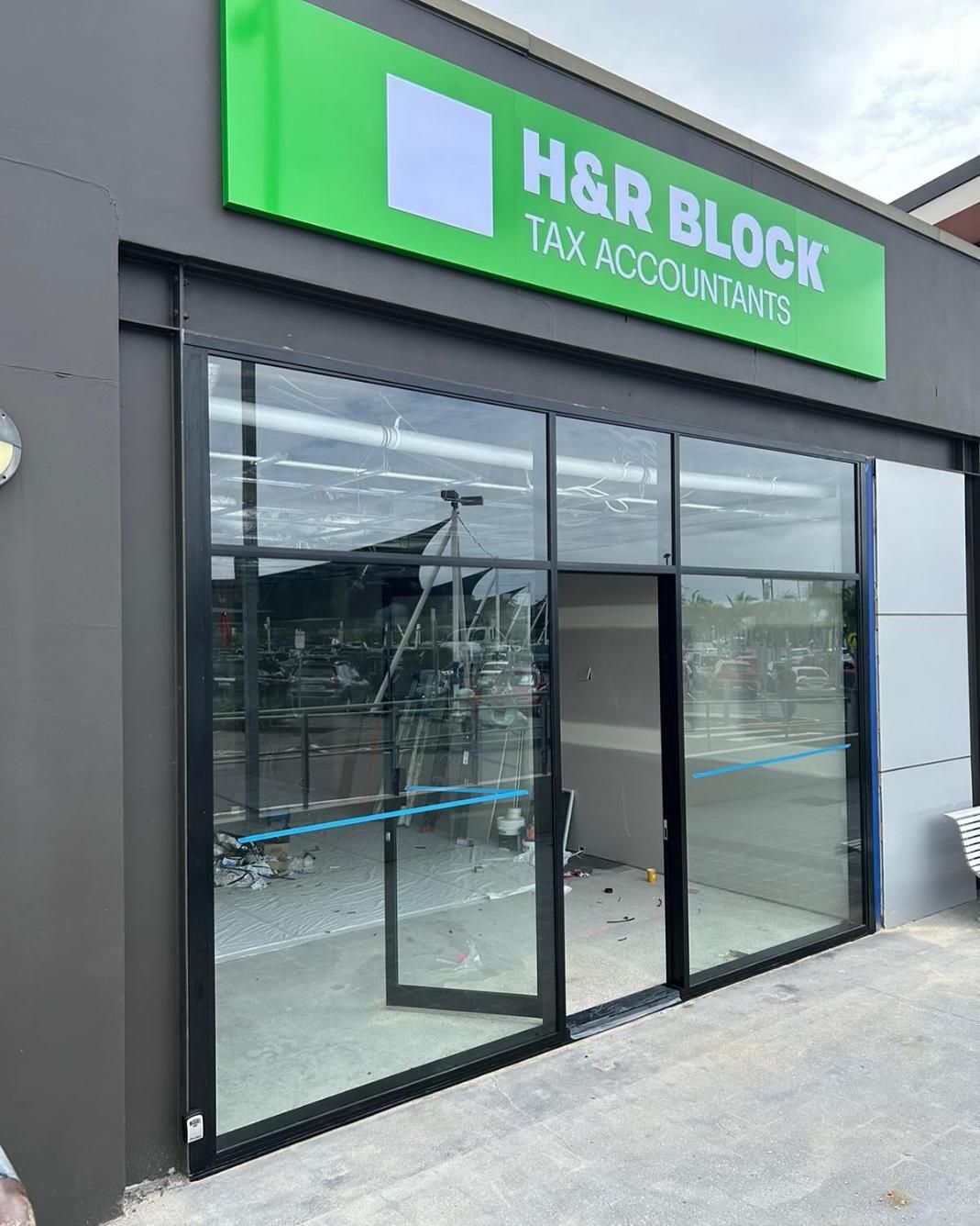A Building With a Green Sign That Says H & R Block Tax Accountants on It — Reflect Glass In Tuggerah, NSW
