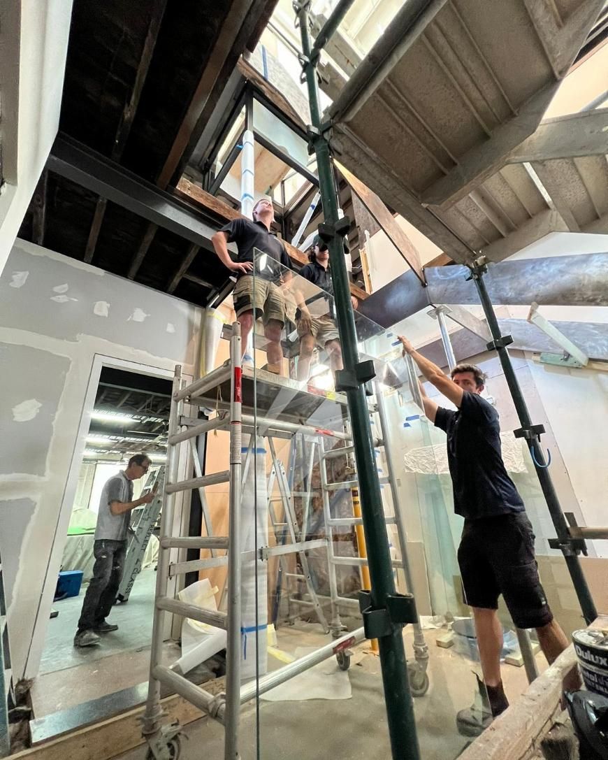 A Group of People Are Working on a Building on Scaffolding — Reflect Glass In Hunter Valley, NSW