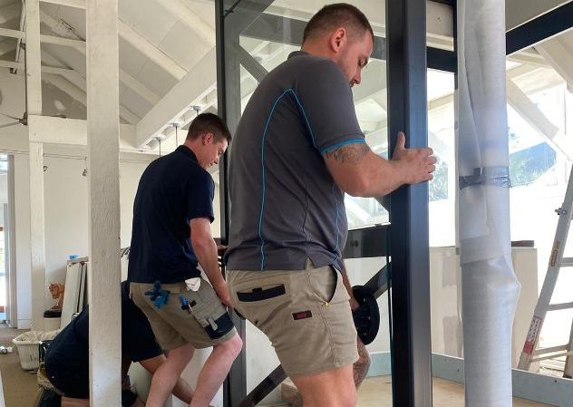 A Bedroom With Sliding Glass Doors and a Rug on the Floor — Reflect Glass In Newcastle, NSW