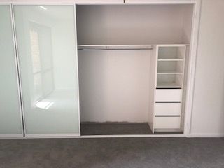 An Empty Closet With Sliding Glass Doors and Shelves — Reflect Glass In Kincumber, NSW