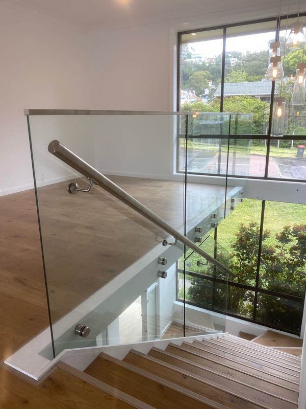 A Staircase With a Glass Railing and Wooden Steps — Reflect Glass In Woy Woy, NSW