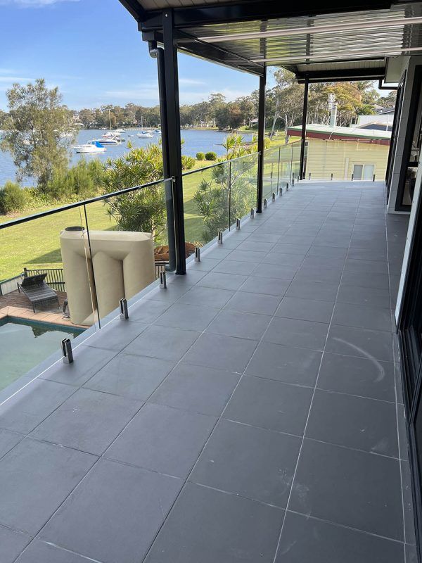 A Balcony With a View of a Lake and a Swimming Pool — Reflect Glass In Lake Macquarie, NSW
