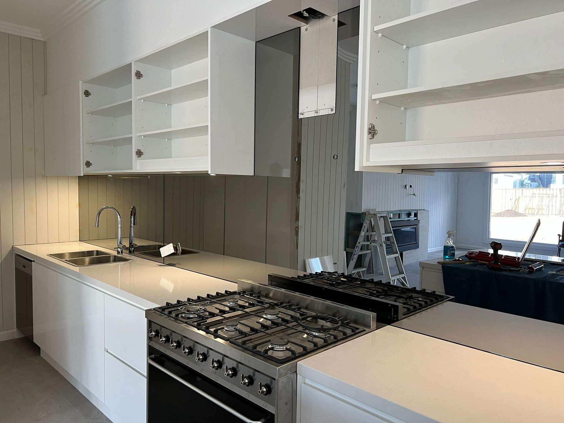 A Kitchen With White Cabinets and Black Counter Tops — Reflect Glass In Tuggerah, NSW