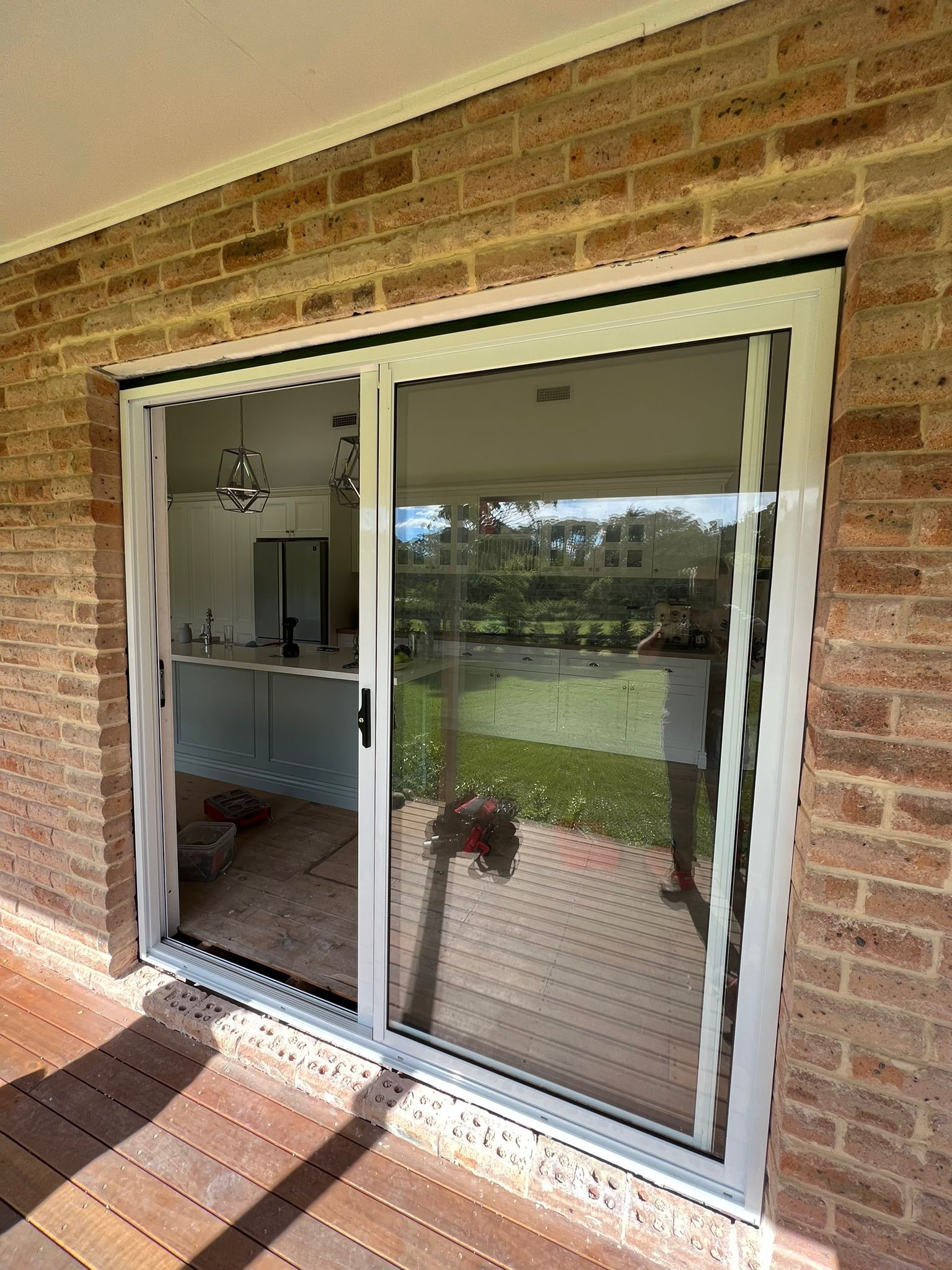 A Pair of Glass Doors With a Black Mat Underneath Them — Reflect Glass In Lake Macquarie, NSW
