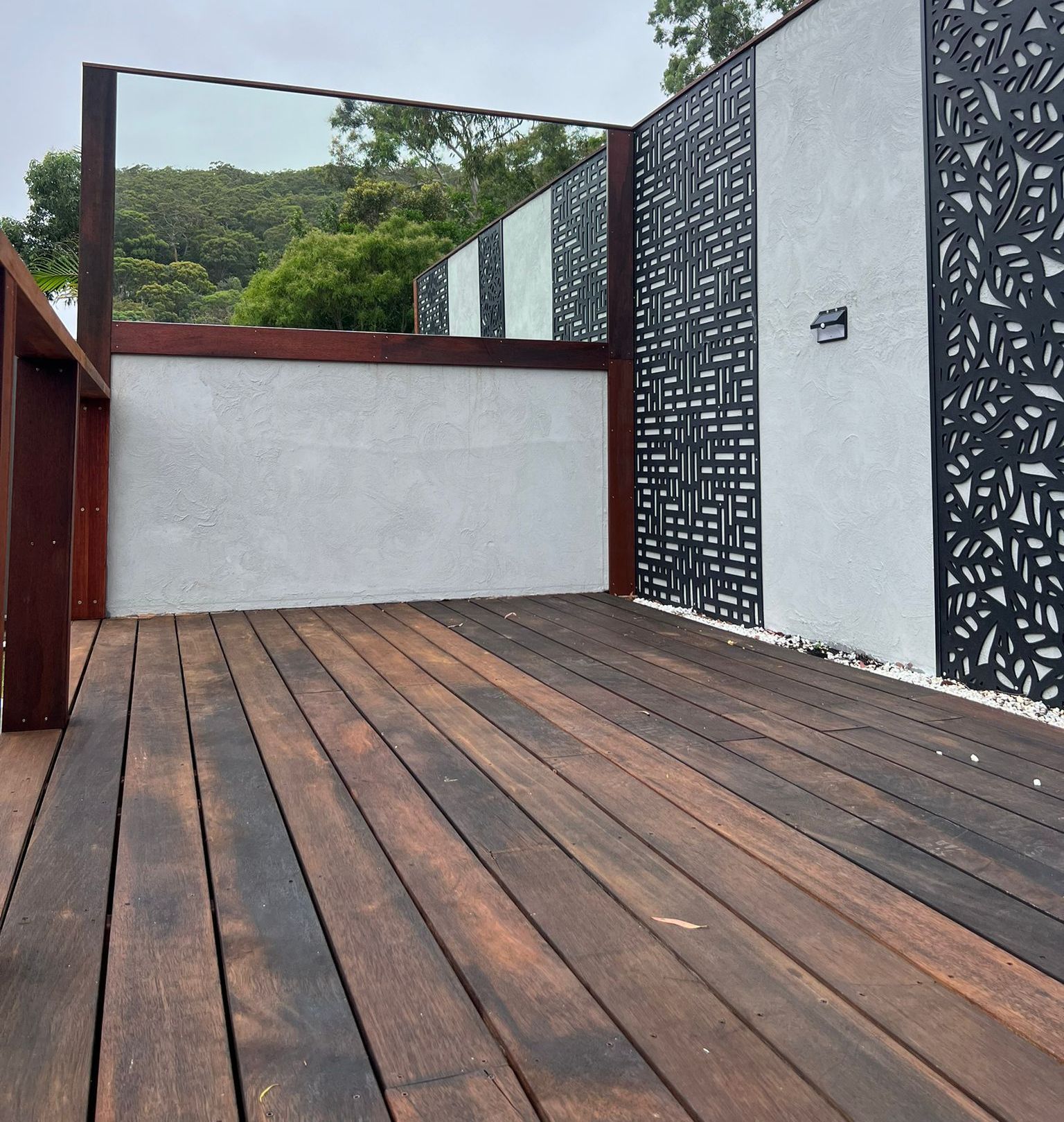 A Wooden Deck with A White Wall Behind It — Reflect Glass In Tuggerah, NSW