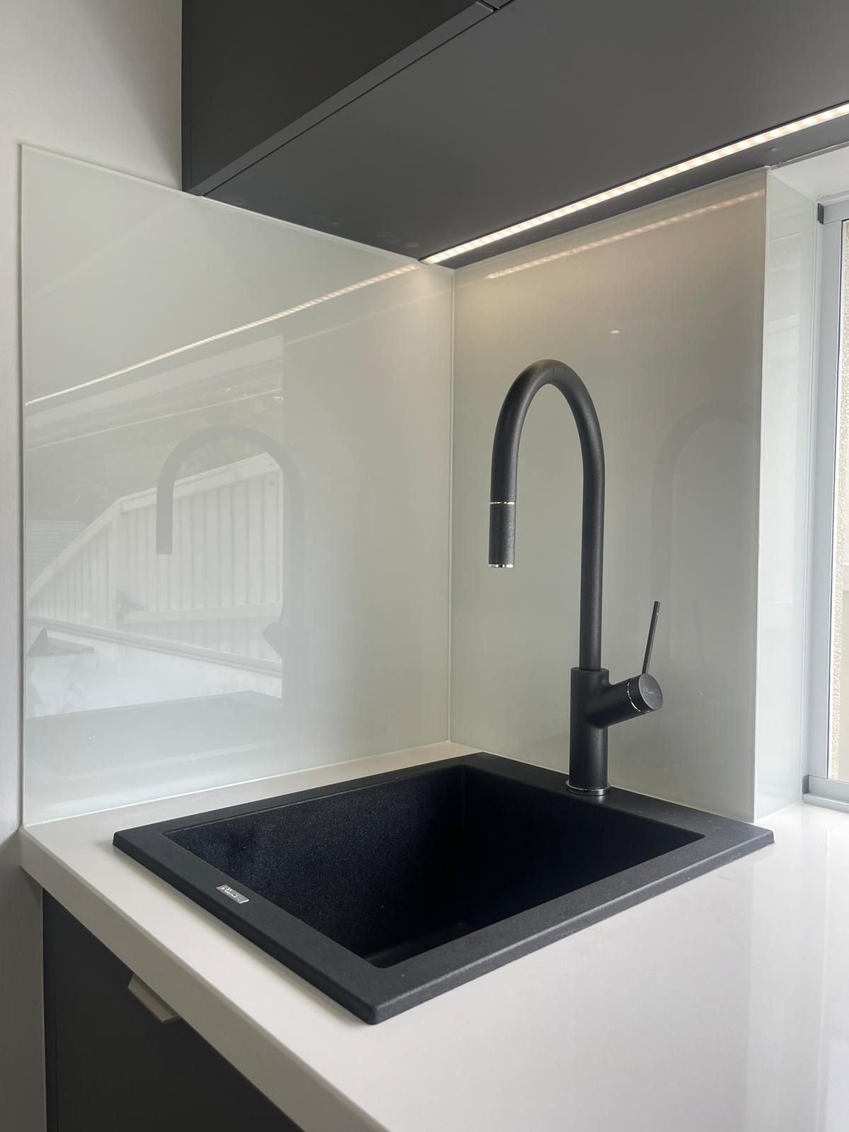 A Kitchen With a Stove Top Oven, a Sink, and a Mirrored Backsplash — Reflect Glass In Tuggerah, NSW