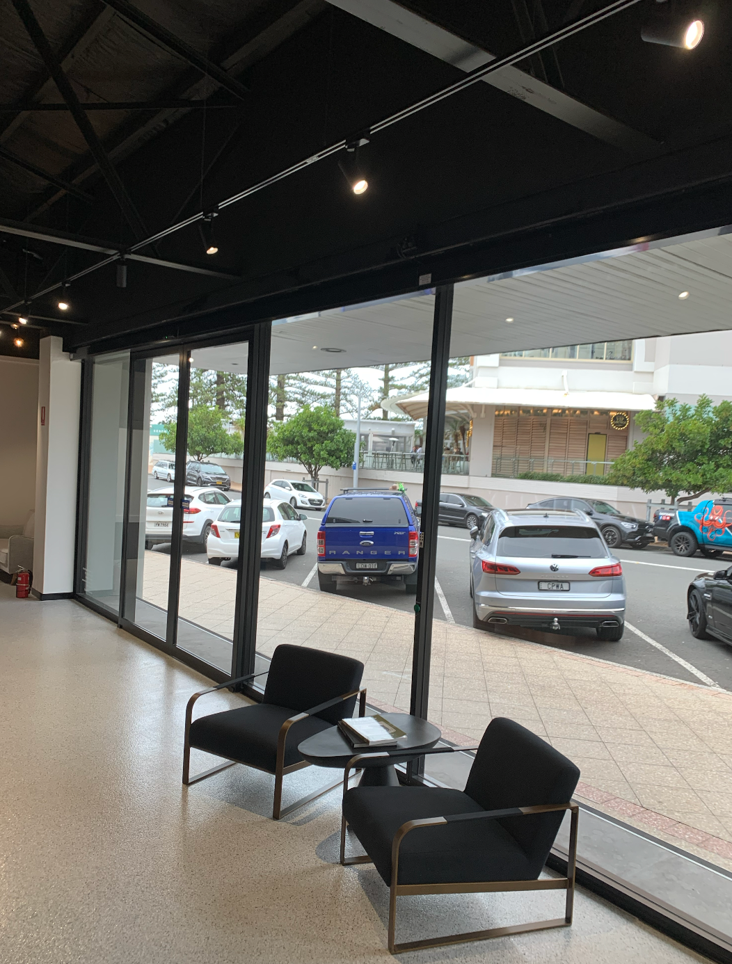 A Room with Two Chairs and A Table with Cars Parked — Reflect Glass In Tuggerah, NSW