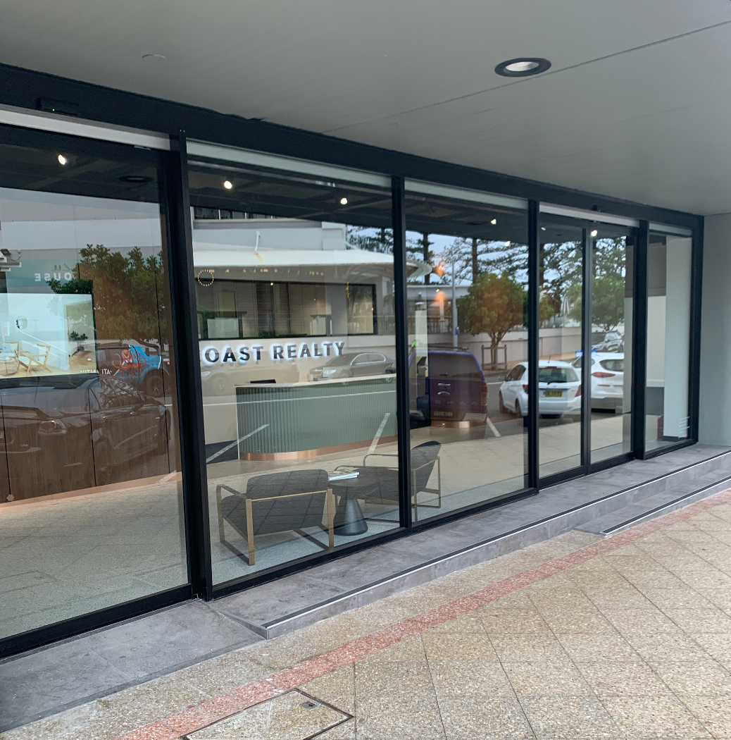 A Shop  With a Large Glass Door and a Brick Wall — Reflect Glass In Kincumber, NSW