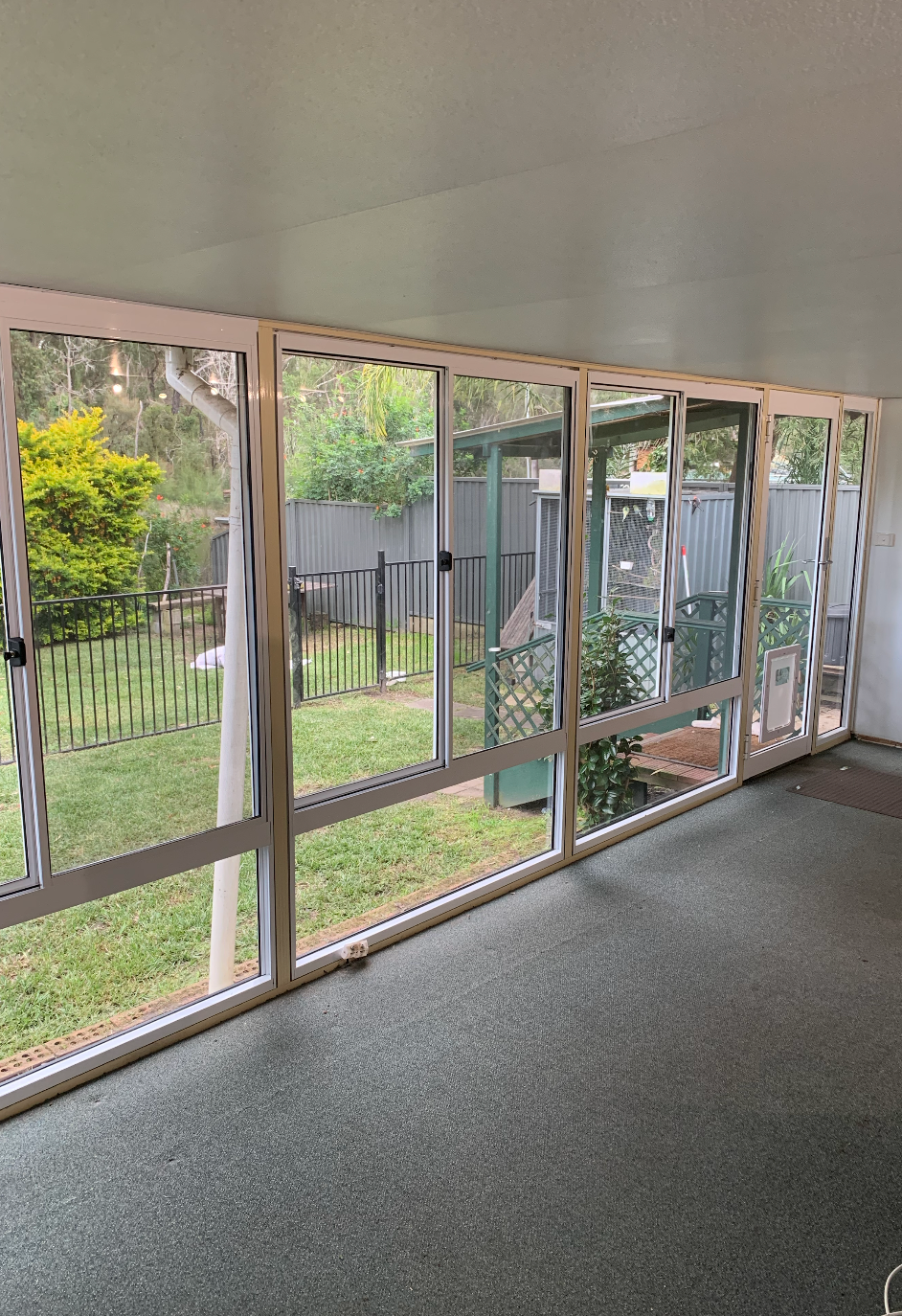 A Close Up of a Window on a Building With Trees in the Background — Reflect Glass In Newcastle, NSW