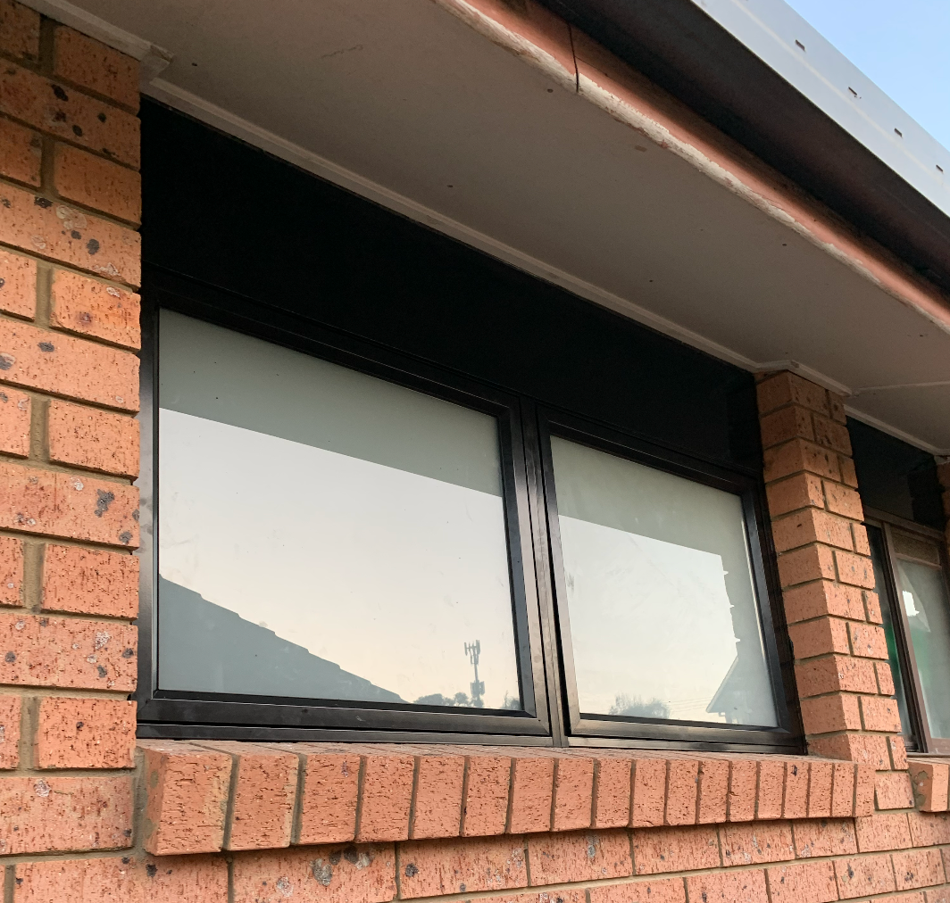 A Drill and a Vacuum Cleaner Are Sitting on a Window Sill — Reflect Glass In Tuggerah, NSW