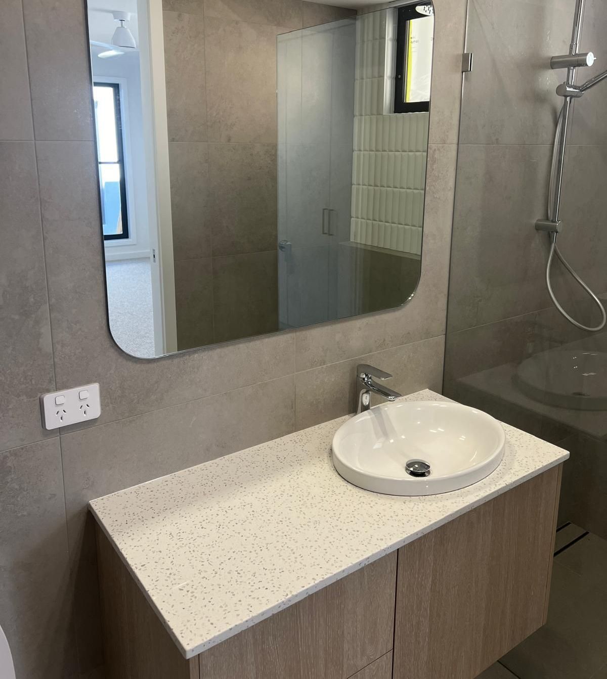 A Bathroom With a Sink and a Round Mirror — Reflect Glass In Newcastle, NSW