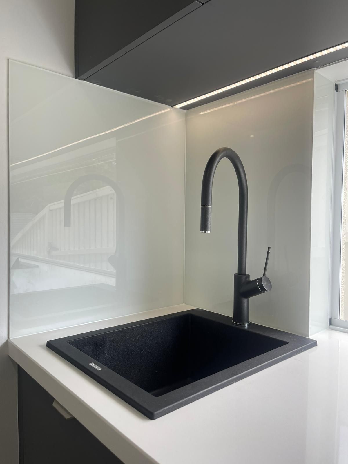 A Kitchen With White Cabinets and a Black Stove Top Oven — Reflect Glass In Tuggerah, NSW