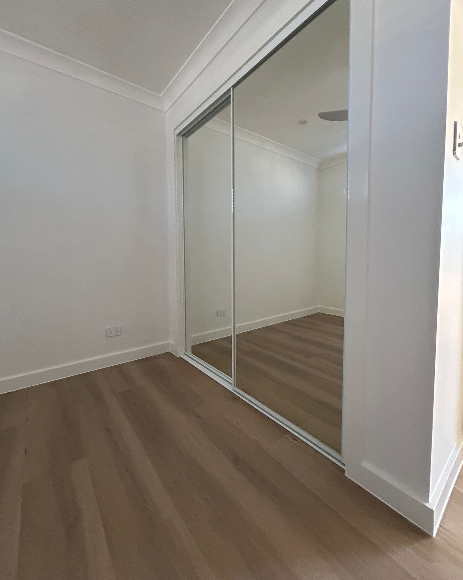 A Bedroom With White Sliding Glass Doors and a Window — Reflect Glass In Tuggerah, NSW