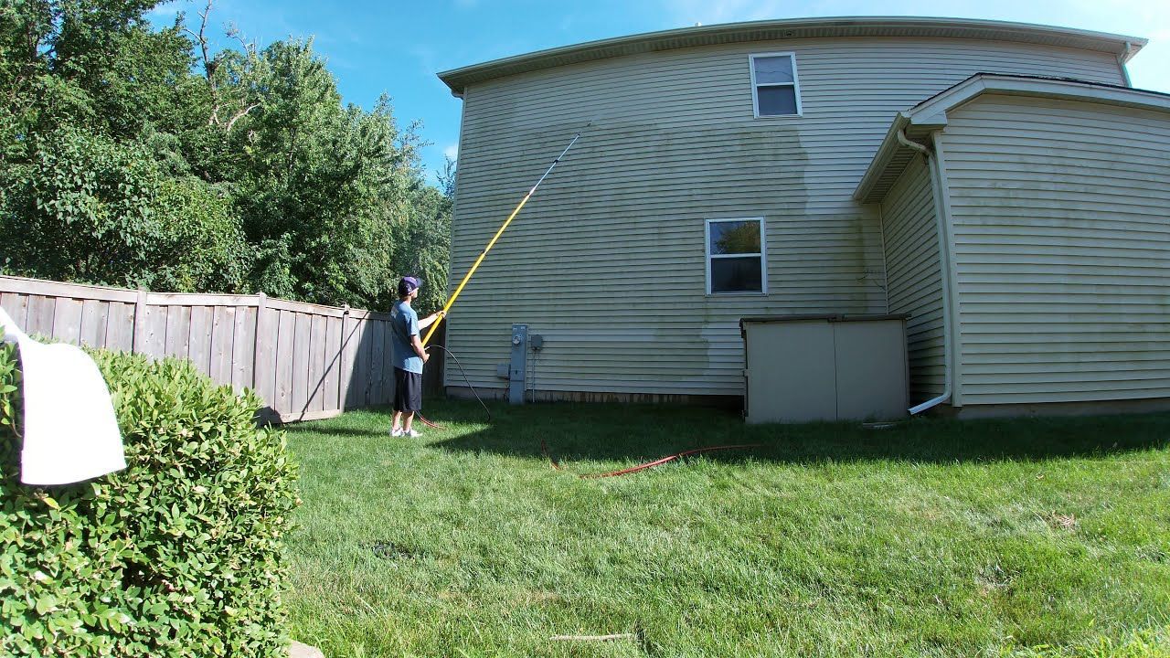 An example of an extension being used to pressure wash a high area on a home.