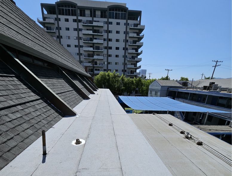 The roof of a building with a large building in the background
