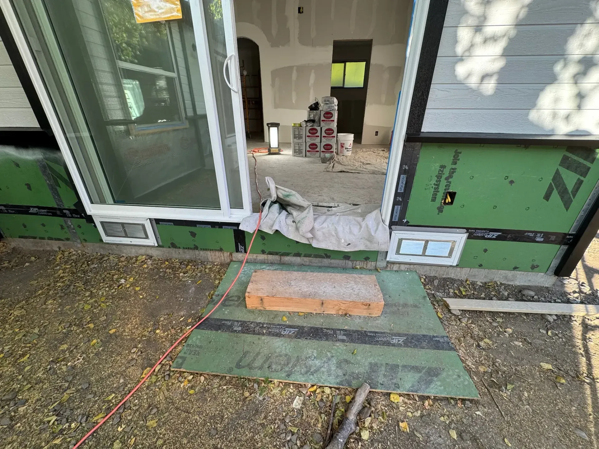 Damaged storefront entrance with broken glass, debris, and a ramp leading inside