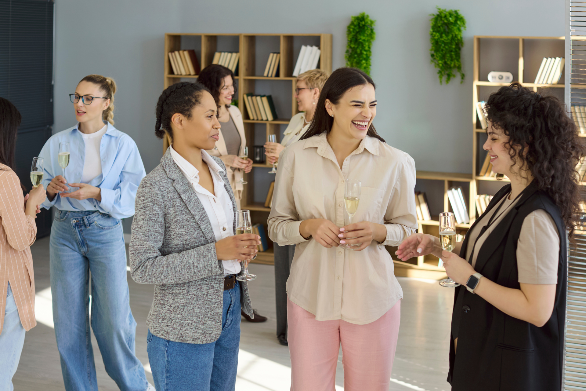 People chatting with drinks at a casual office networking event in a bright lounge