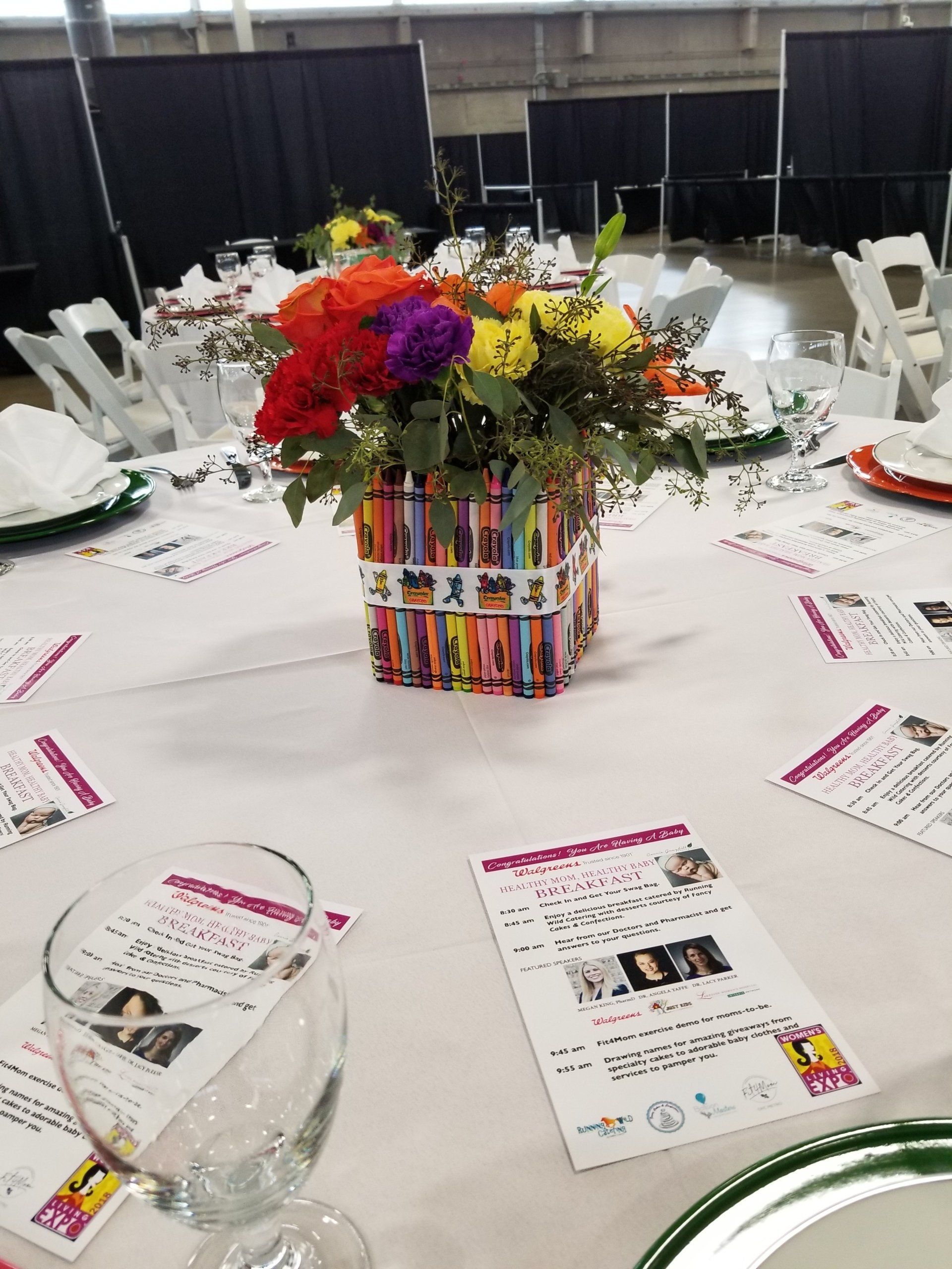Table setting with floral centerpiece and printed materials at an event.