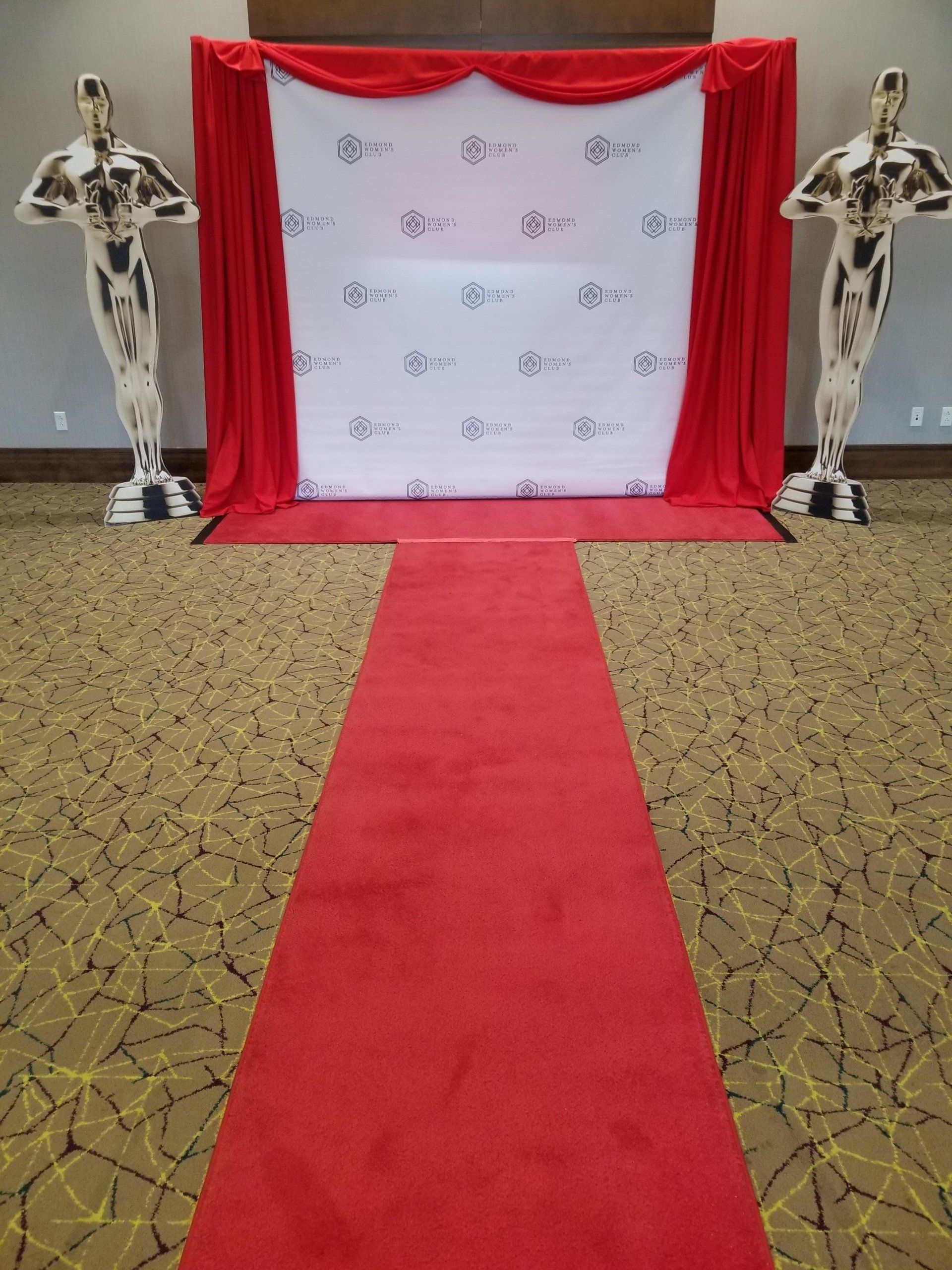 Red carpet entrance with an Oscar-themed backdrop and statue standees.