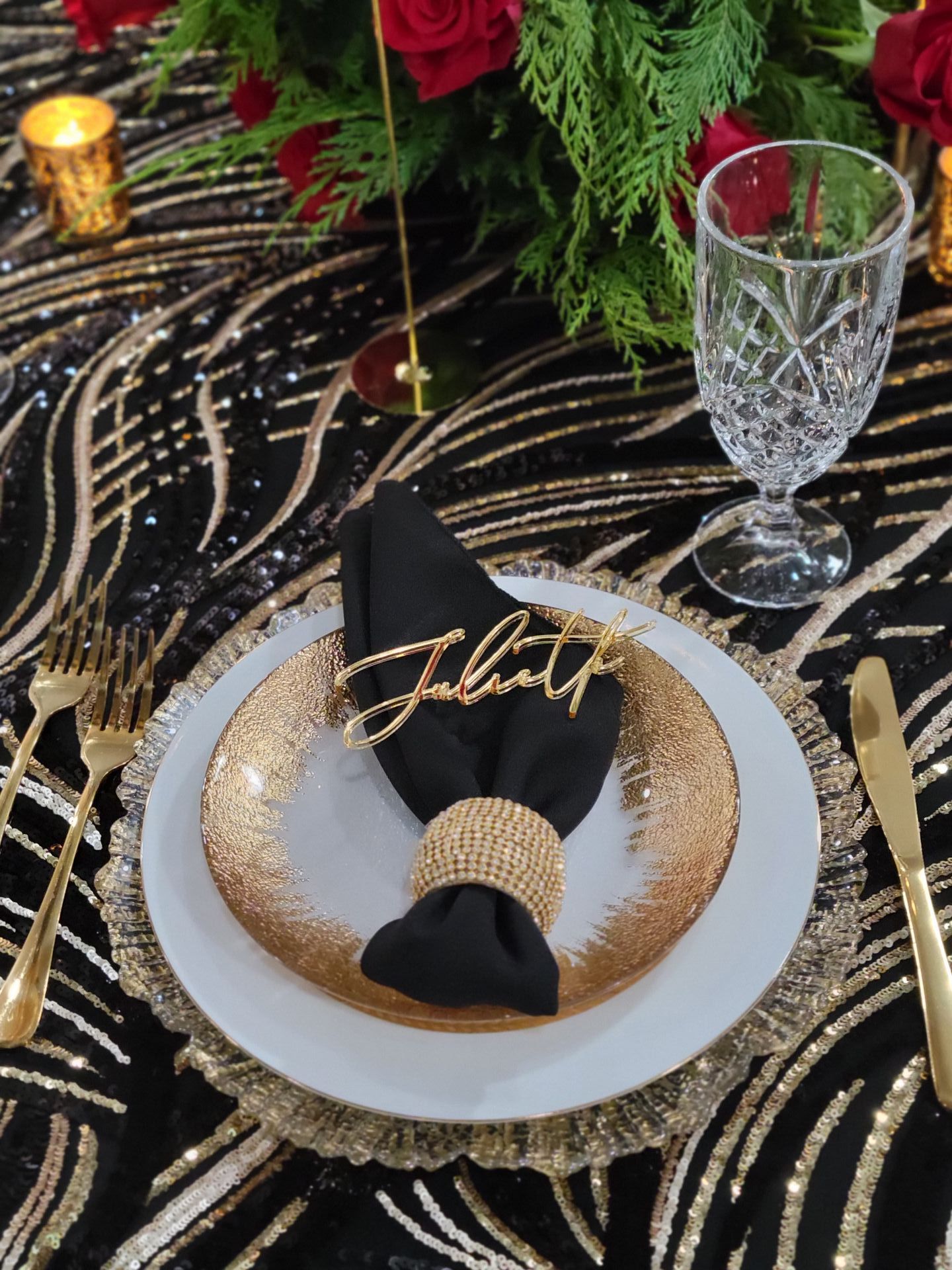 Elegant table setting with gold accents, black napkin, place setting, and name card.