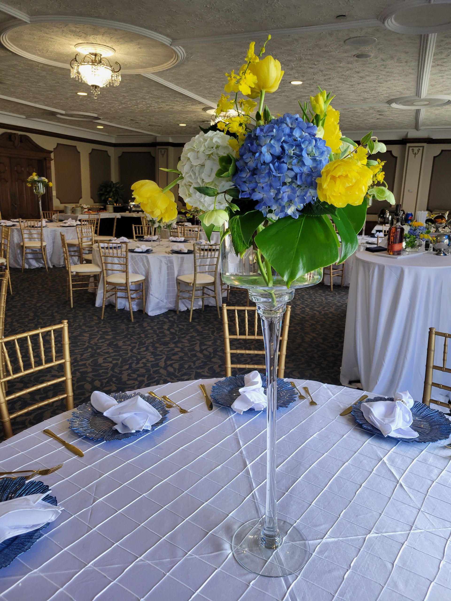 Wedding reception with flower centerpiece and round tables covered in white linens.