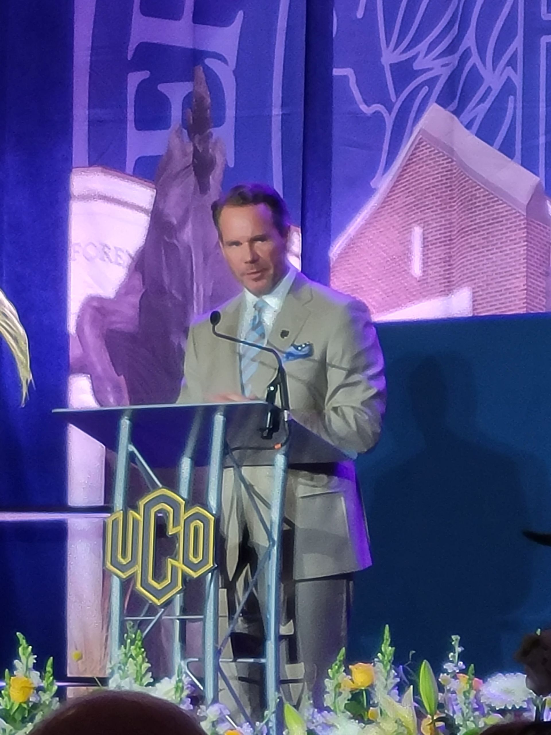 Man in suit speaking at a podium with