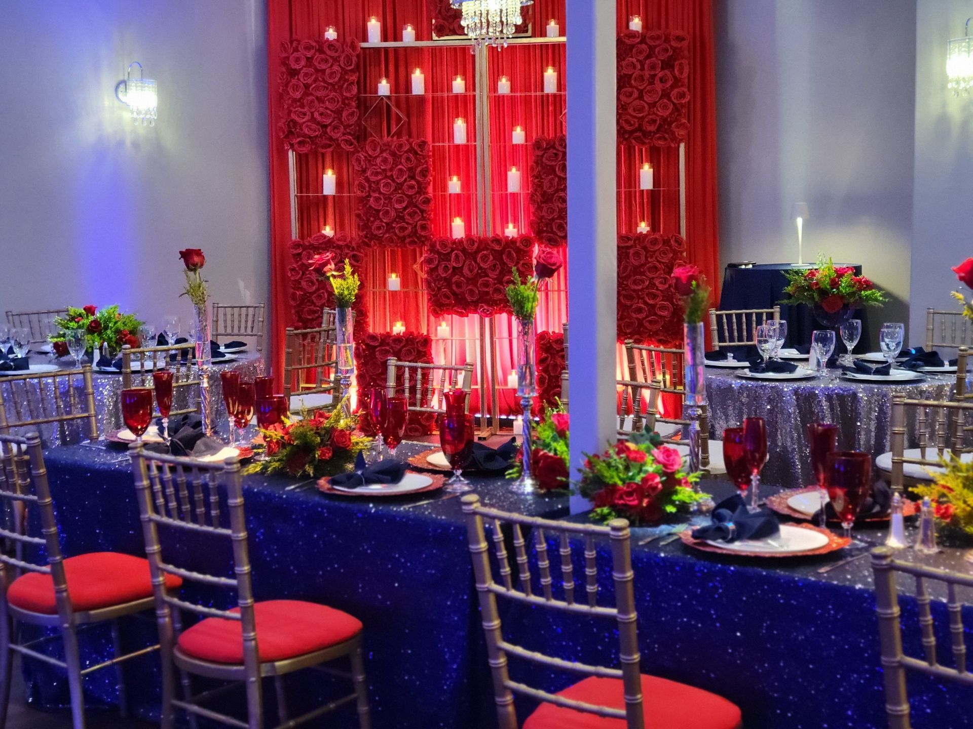Formal event space with decorated tables, red and blue color scheme.