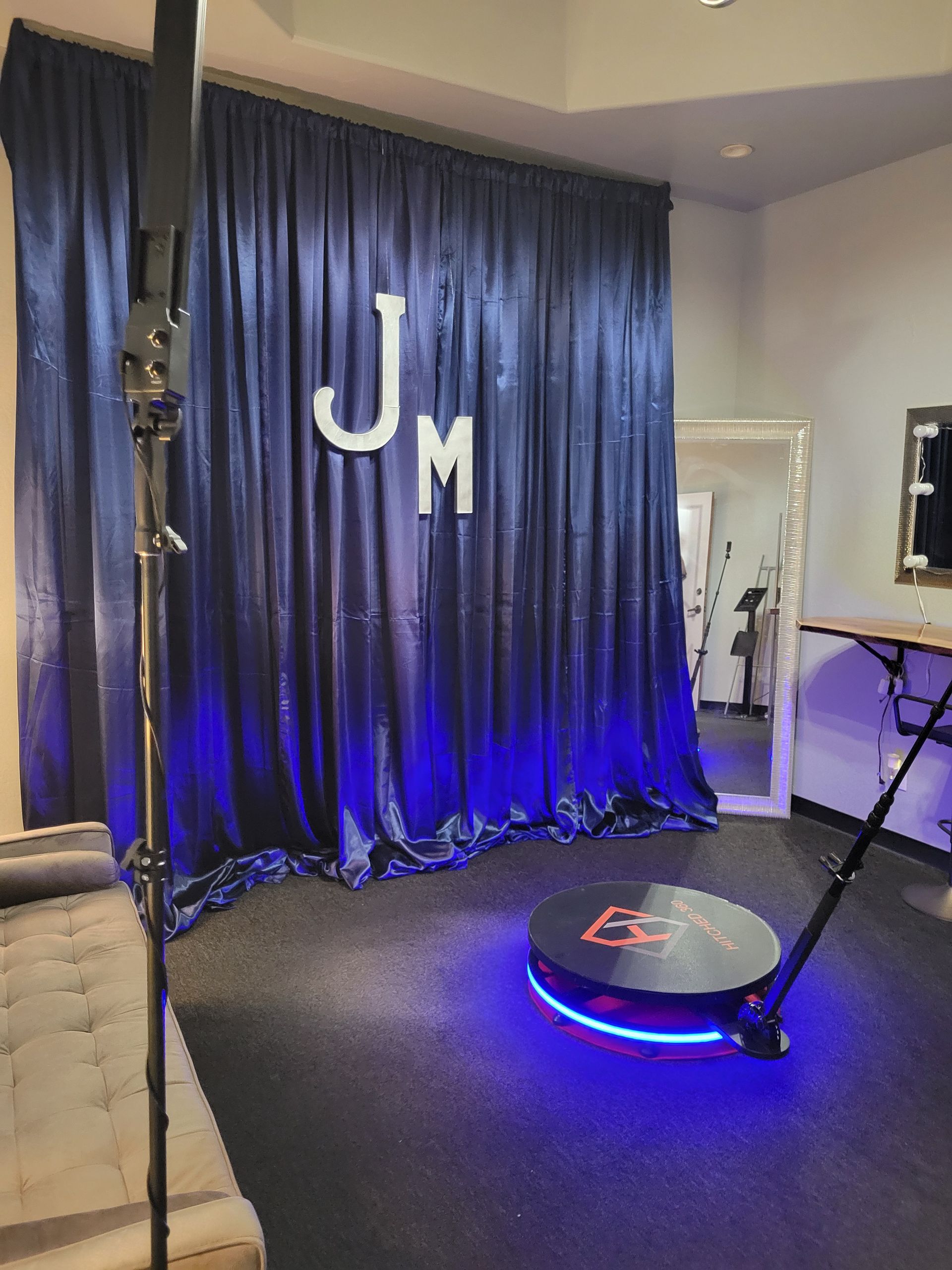 Photo booth setup with a blue curtain backdrop, initials 