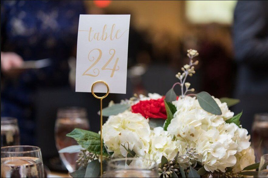 Table setting with floral arrangement and gold table number 24.