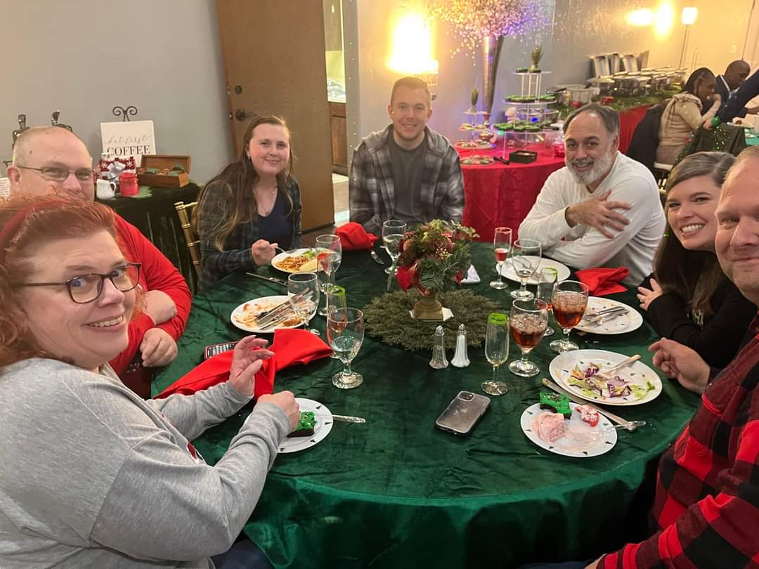 People at a holiday dinner table with festive decorations.