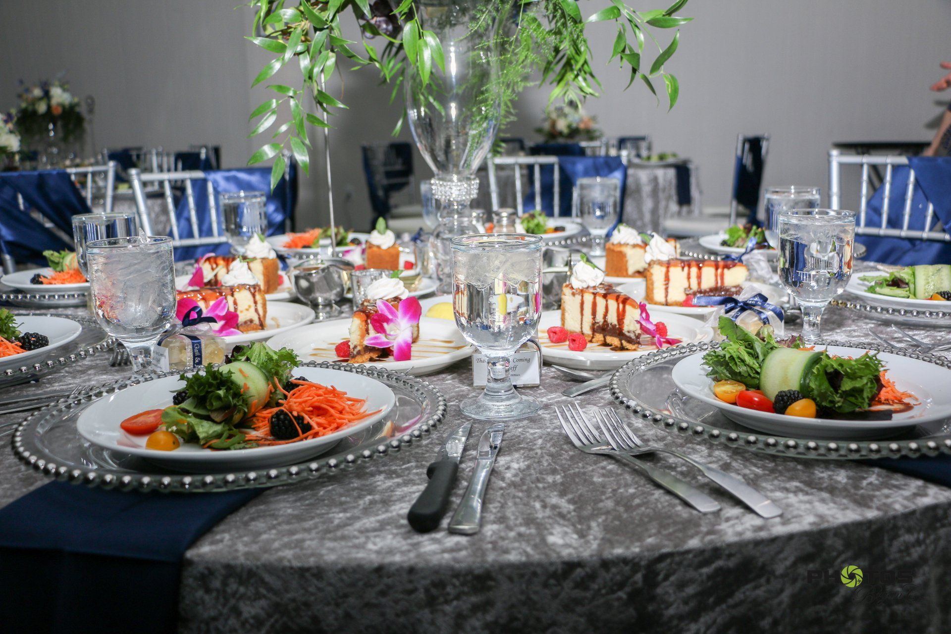 Elegant dining table set for a formal event with food and floral arrangements.