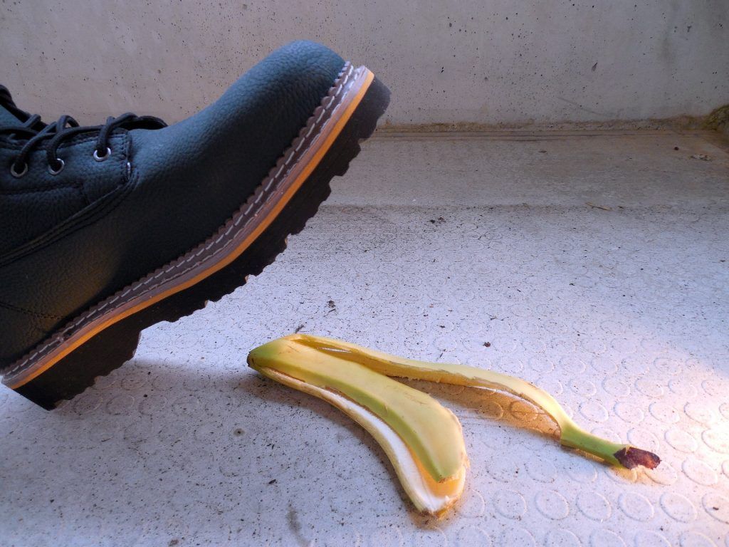 A person 's foot is slipping on a banana peel