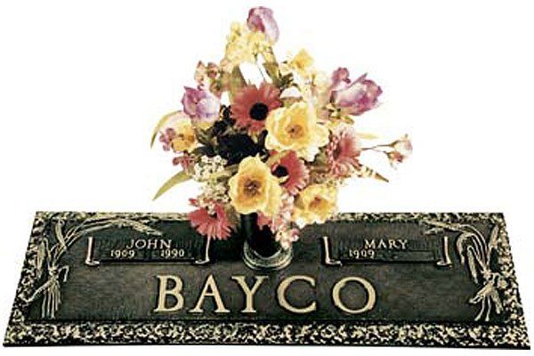 A gravestone for john and mary bayco with a vase of flowers