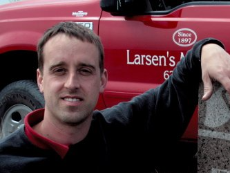 A man standing in front of a larsen 's truck