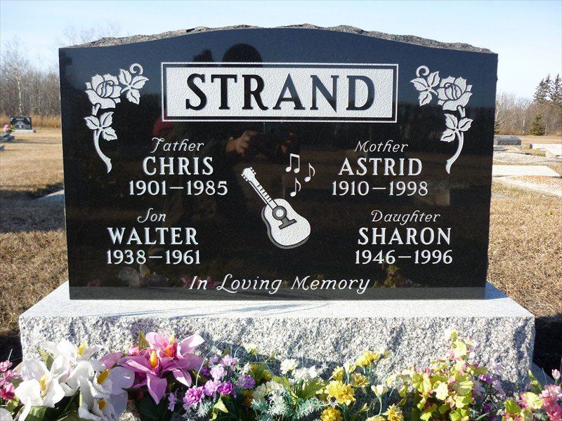 A black gravestone with the name strand on it