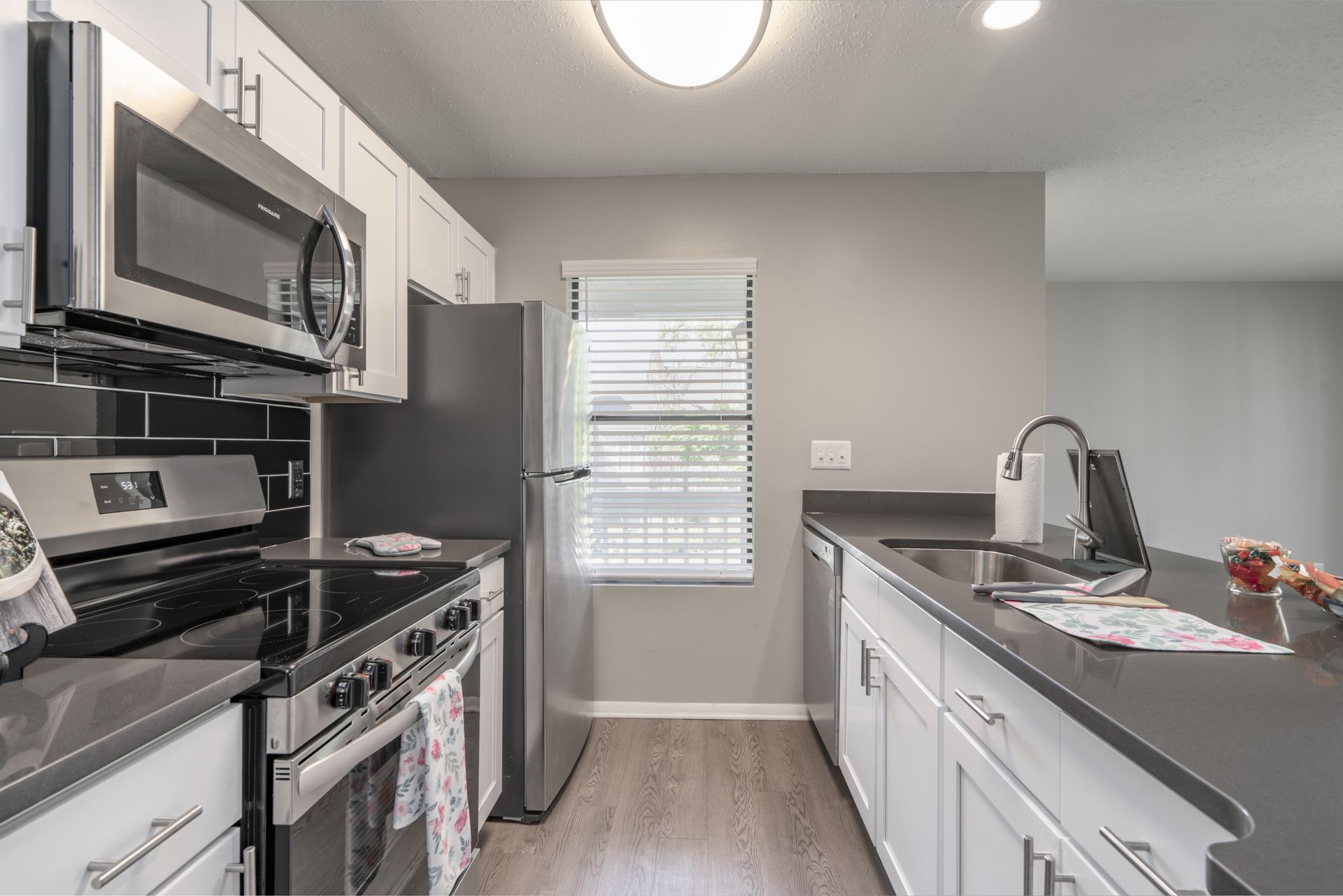 Modern kitchen with stainless steel appliances, white cabinets, and dark countertop. Contact us today to take a tour of our 1, 2, and 3-bedroom apartments for rent in Charlotte, NC.