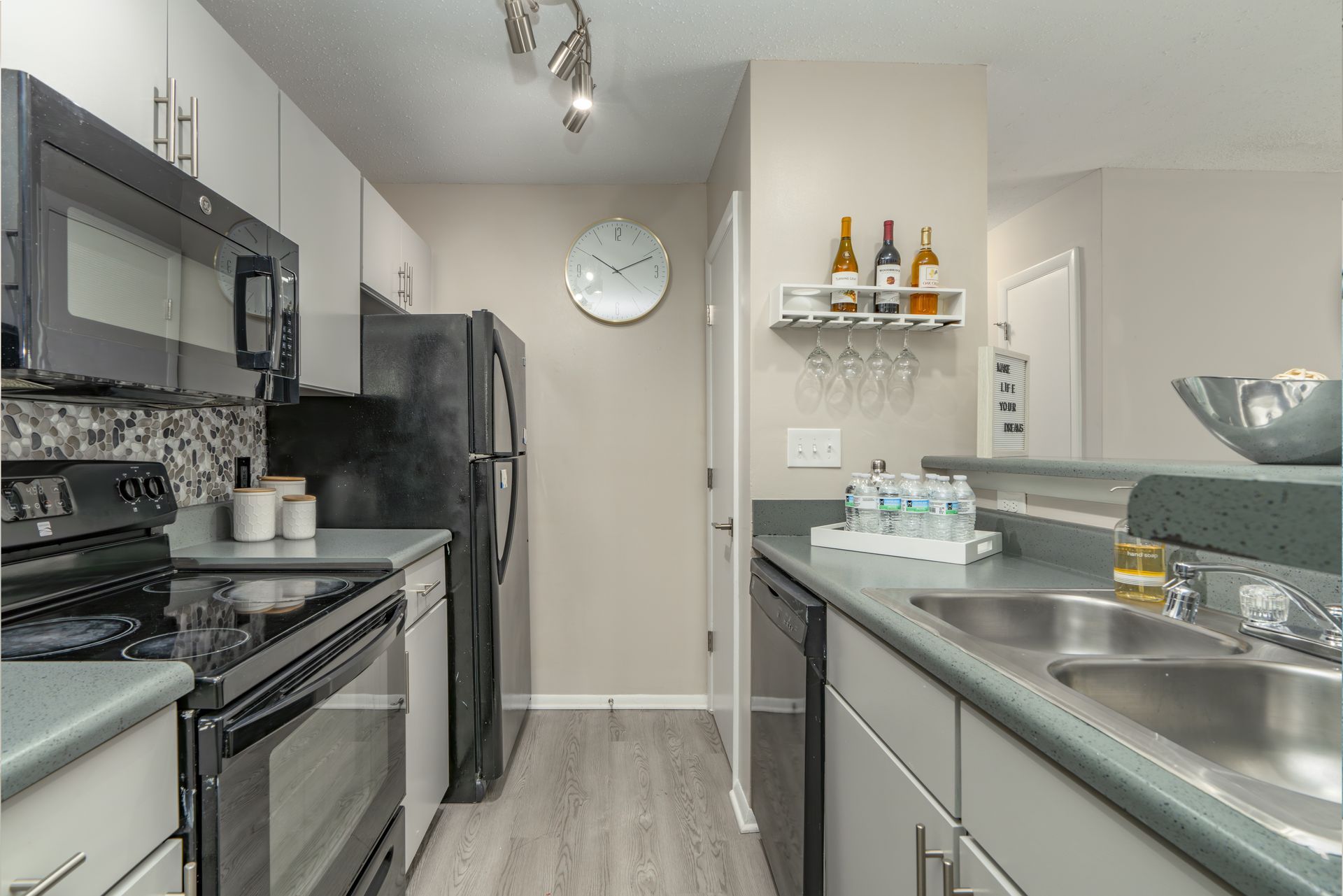 Kitchen with gray countertops, stainless steel appliances, and white cabinets. Contact us today to take a tour of our 1, 2, and 3-bedroom apartments for rent in Charlotte, NC.