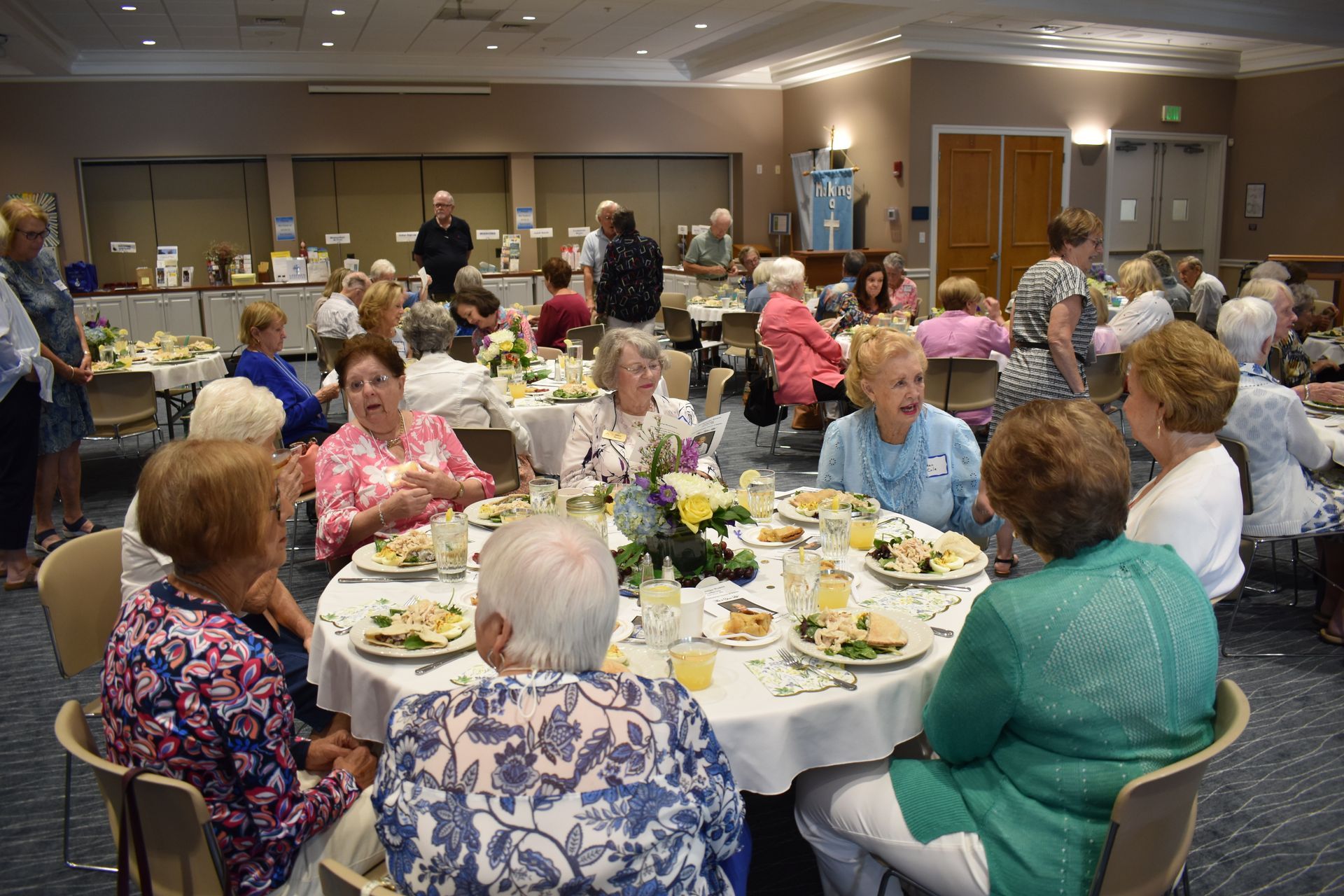 Attendees interacting and smiling during an active Women's Ministries fellowship gathering.