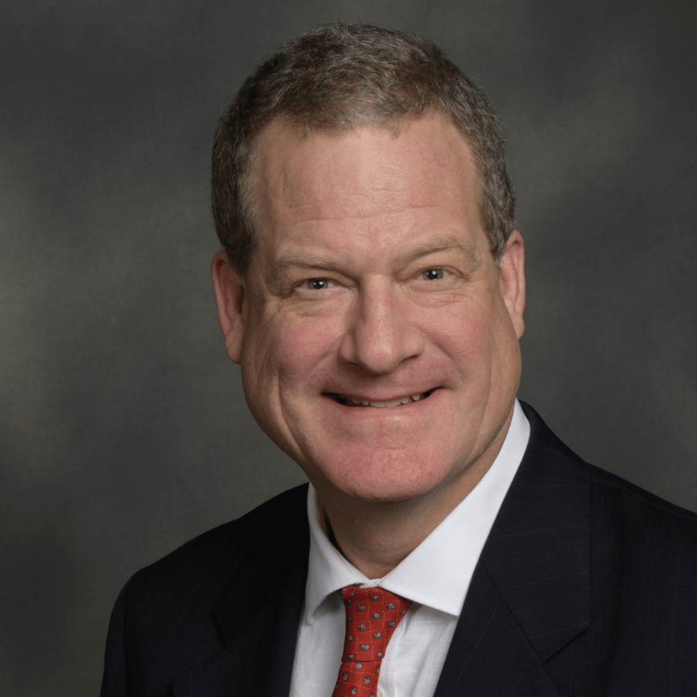 Headshot of Dr. Brice Gerlach smiling against a gray background.
