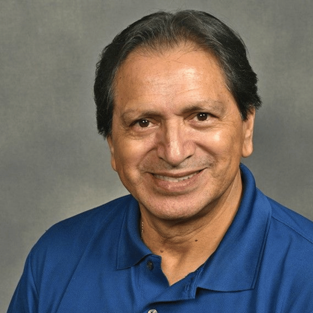 Headshot of Dr. Brice Gerlach smiling against a gray background.