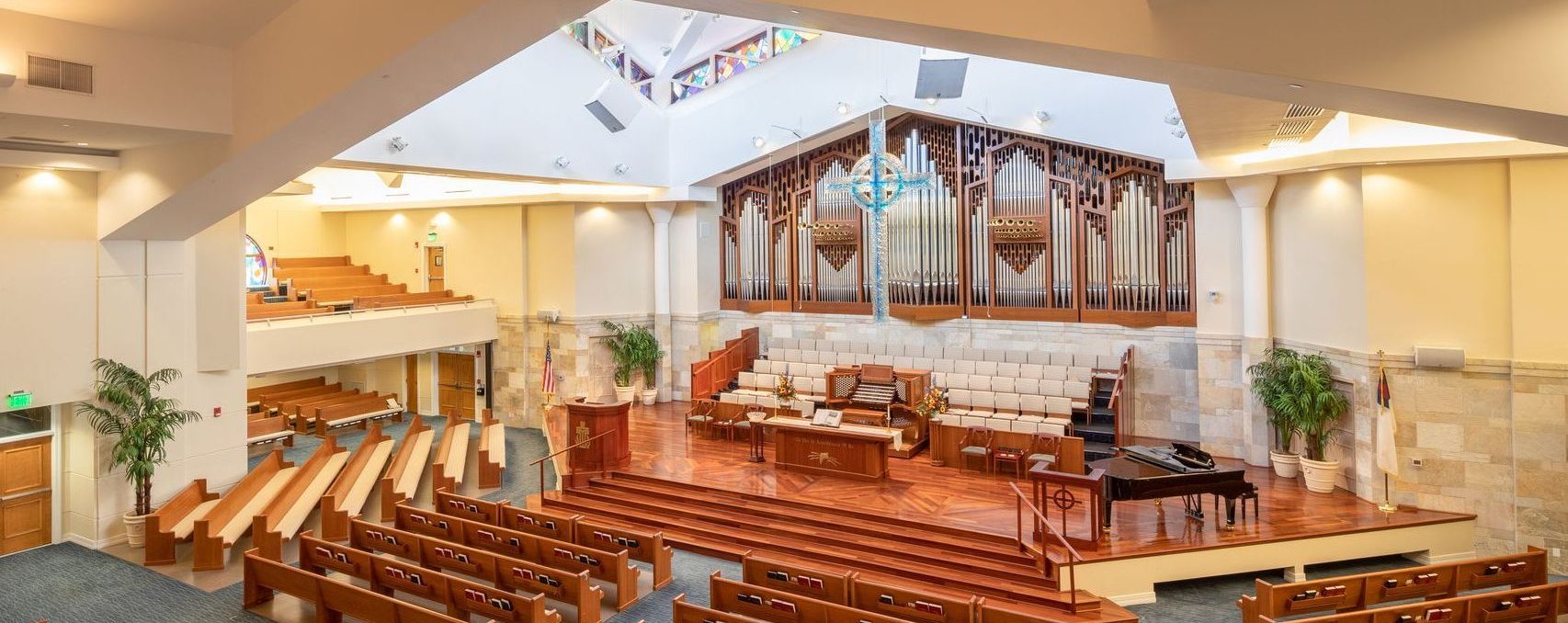Interior view of the church sanctuary showing wooden pews, a large pipe organ, and the altar area.