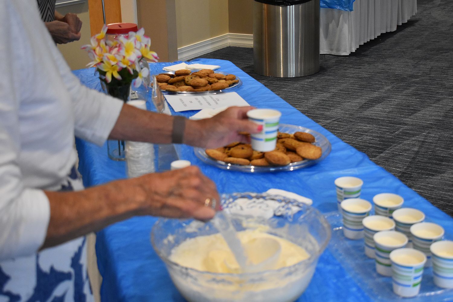 A close-up view of someone pouring and serving refreshments from a punch bowl at a church community social event.