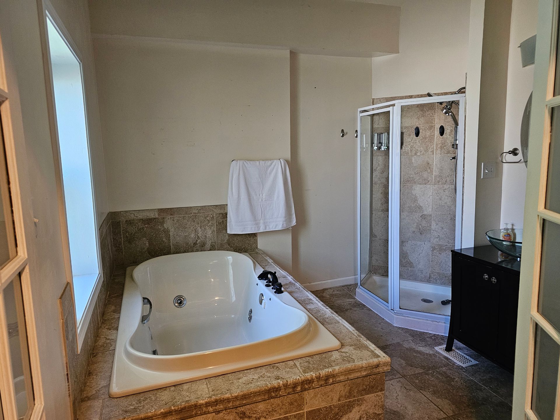 A bathroom with a jacuzzi tub and a walk in shower.