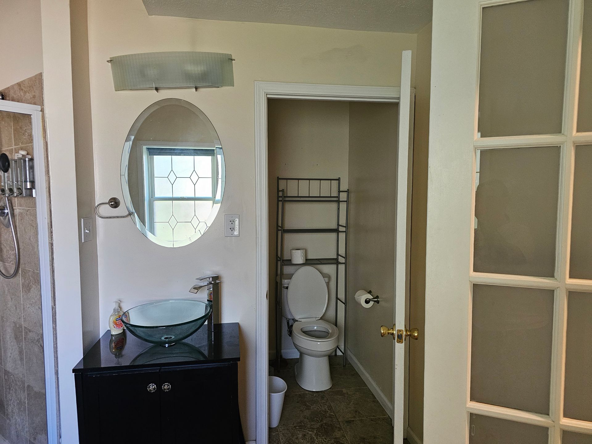 A bathroom with a toilet a sink and a mirror