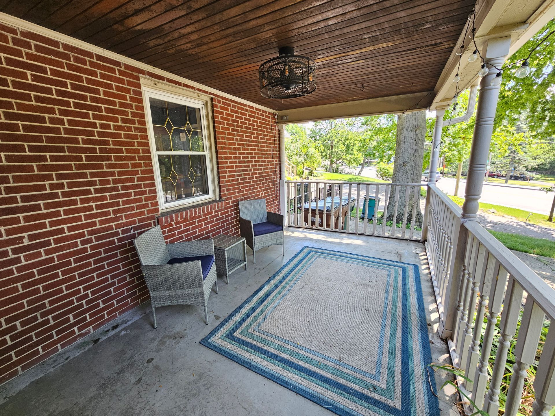 A porch with a rug and chairs on it