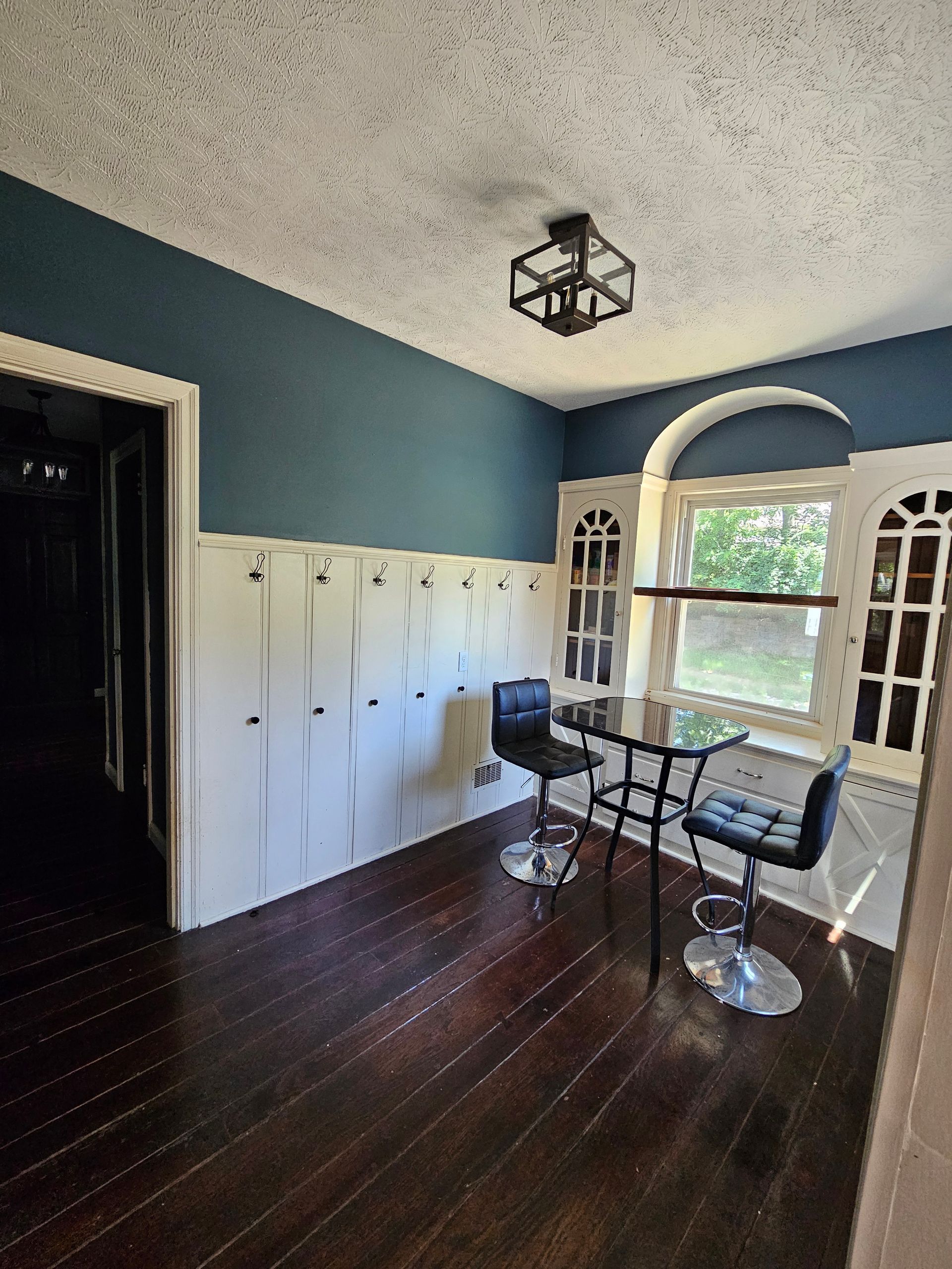 A room with a table and chairs in it and a window.